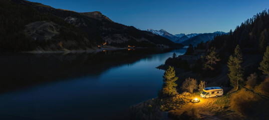 Camping in a motorhome on a mountain lake at night