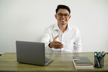 young asian businessman in a workplace shaking hands for closing a good deal, wear white shirt with glasses isolated