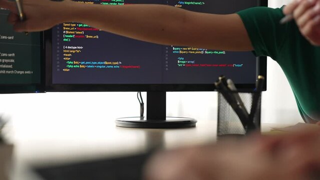 Slow motion back end software developer engineer for computer programming working together on debugging writing computing code, solving complex algorithms display on monitor in office. Burgeoning