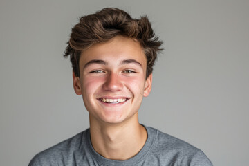 A young man with braces on his teeth smiles for the camera