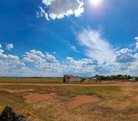 View of a house, a tank with gasoline and a small plane on a sunny day.