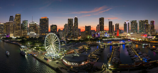 American urban landscape at night. Miami marina and Skyviews Observation Wheel at Bayside Marketplace with reflections in Biscayne Bay water and skyscrapers of Brickell, city's financial center