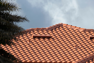 Closeup of house rooftop covered with ceramic shingles. Tiled covering of building