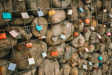 Metal locks on a grid with stones on the promenade by the sea. Customs and traditions of lovers and newlyweds.Locks of lovers and newlyweds on the embankment.