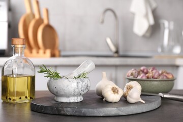 Obraz na płótnie Canvas Fresh raw garlic, rosemary and oil on grey table
