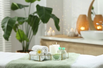 Composition with different spa products and burning candles on table indoors. Space for text