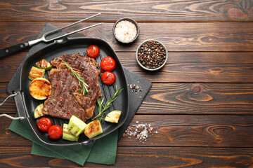 Delicious grilled beef steak and vegetables served on wooden table, flat lay. Space for text