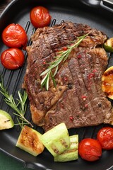 Delicious grilled beef steak and vegetables in frying pan, top view