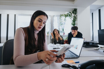 A dedicated businesswoman calculates finance figures on a calculator in a bustling office...