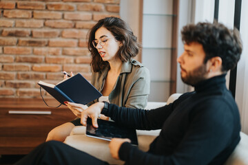 Professional woman sharing ideas with male colleague in a modern office setting, teamwork and collaboration concept.