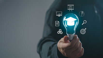 man holding lightbulb showing graduation hat, Internet education course degree, study knowledge to...