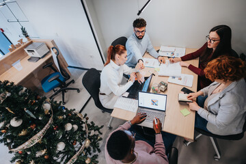 Collaborative business professionals analyze data and discuss strategies in a creative office. Positive atmosphere and teamwork drive innovation and market expansion.