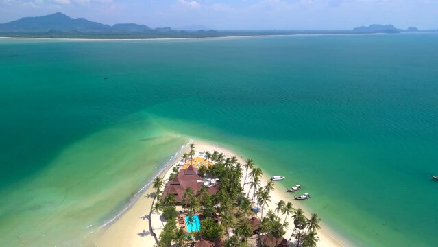 Koh Mook tropical Island in the Andaman Sea in Trang Thailand. Drone aerial view at Koh Muk a tropical island with palm trees and white soft sand with a turqouse colored ocean