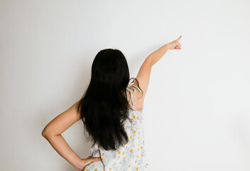 a woman points in a direction from the back view