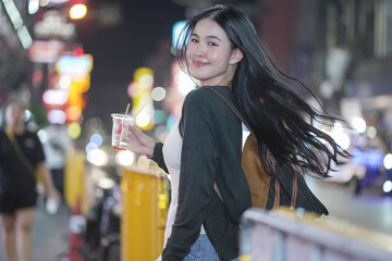 asian woman traveller backpack. Happy young tourist woman on street. Young woman at Bangkok Chinatown street night market. city lifestyle shopping and eating street food concept. travel. vacation.