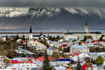 Scenic City - Late fall in Reykjavik shows the surrounding snow capped mountains. - obrazy, fototapety, plakaty