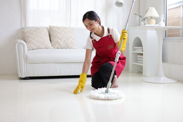 Young Asian woman cleaning the house with a mop.