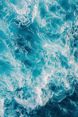 Fototapeta na wymiar Vertical aerial view from above of turquoise ocean water with splashes and foam for abstract natural background and texture.