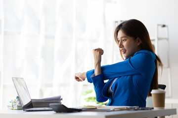 Asian woman working in office stretching relaxation during break to relieve fatigue.
