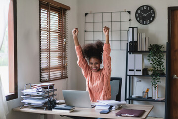 African american businesswoman reads good news and raising arms to celebrate with work successful