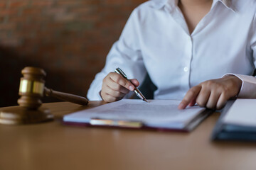 Hands of lawyer woman pointing on paper to reading legal agreement and signing on business contract