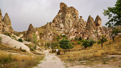 Uchisar Castle entrance path with view of the extensively hollowed out rock pillars, spires and caves leading to the top of the castle near  Goreme,Cappadocia Region,Turkey.