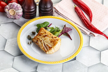 Roasted cod fish steak with salad