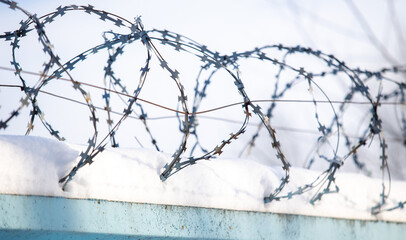 A barbed metal fence covered in snow.