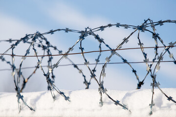 A barbed metal fence covered in snow.