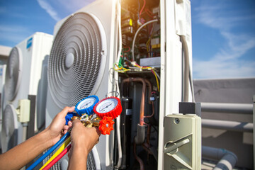 Heat and Air Conditioning, HVAC system service technician using measuring manifold gauge checking...