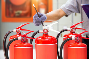 Fire extinguisher has hand engineer checking pressure gauges to prepare fire equipment for...