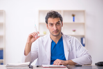 Young male doctor in vaccination concept