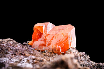 Wulfenite crystal isolated on black background. macro detail close-up rough raw unpolished...