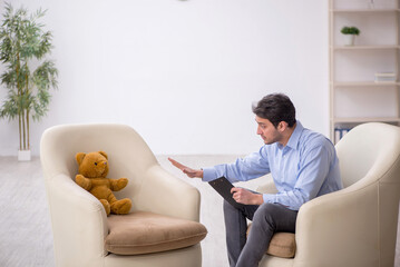 Young male psychologist meeting with toy bear