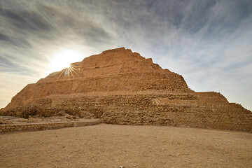 Suns shining behind the walls of the step pyramid of king Djoser in Saqqara, Egypt