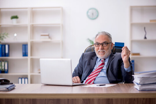 Old male employee holding credit card