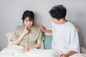 口周りを痛がる女性と心配する男性（ヘルペス・吹き出物・口角炎・虫歯）
