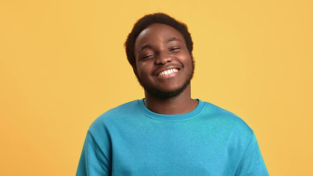 Portrait overjoyed African American young guy laughing with positive emotion isolated on orange