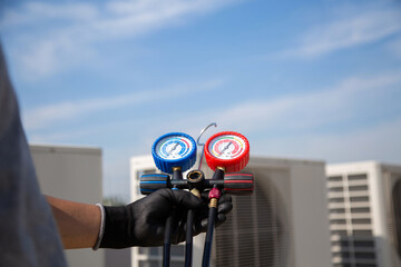 Technician use manifold gauge check and filling refrigerant vacuum pump evacuates industry air conditioning HAVC system maintenance or chiller and air conditioner cleaning filter service.