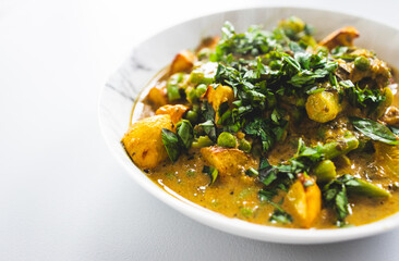 plant-based potato and vegetable green curry with fresh herbs