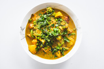 plant-based potato and vegetable green curry with fresh herbs