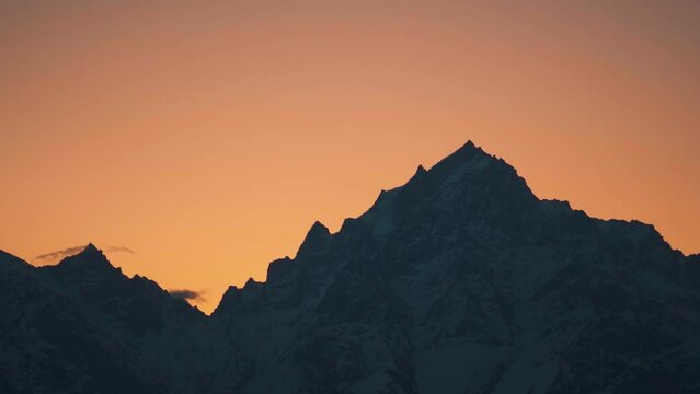 Silhouette shot of snow covered Kinnaur Kailash mountain during the sunrise in winter as seen from Kalpa in Kinnaur, Himachal Pradesh, India. View of Holy Kinnaur Kailash mountain range in morning.