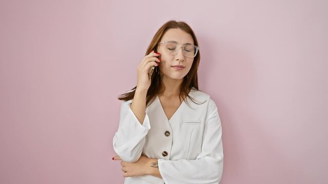 Cute young brunette girl, all smiles, cooking up an idea while on a call, pointing a finger upwards. numero uno on a fancy pink isolate backdrop!