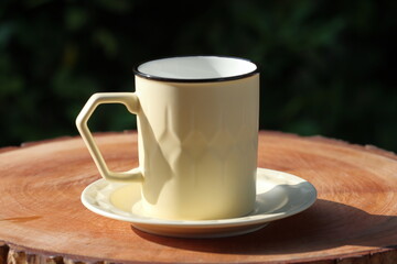 Cup Of Tea Closeup Over Nature Green Background. Pouring green tea in cup. Glass tea pot. Hot healthy drink