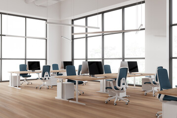 Modern coworking interior with pc desktop and armchairs in row, window