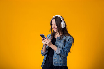 Portrait of girl with headphone and smartphone playing video game.
