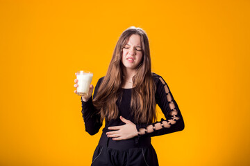 Girl with glass of milk doesn't like it. Dairy Intolerant person. Lactose intolerance, health care concept.