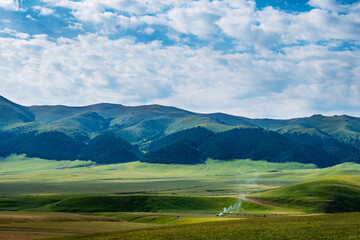 Traditional summer pasture in the mountains of nomadic peoples of Asia. Yurt on a pasture. Assy plateau. Kazakhstan