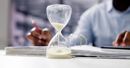 Hourglass And Time Crunch With Document
