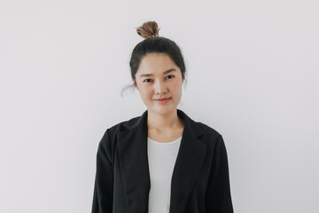 Asian Thai woman smiling and looking at camera, businesswoman wearing blazer suit and bun...
